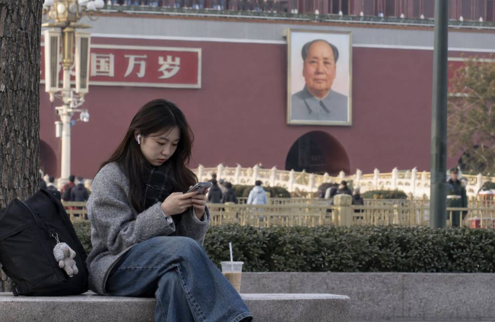 jeune chinoise avec le portrait de Mao en arri&egrave;re plan